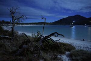 view of a moonlit Wineglass Bay from our campsite