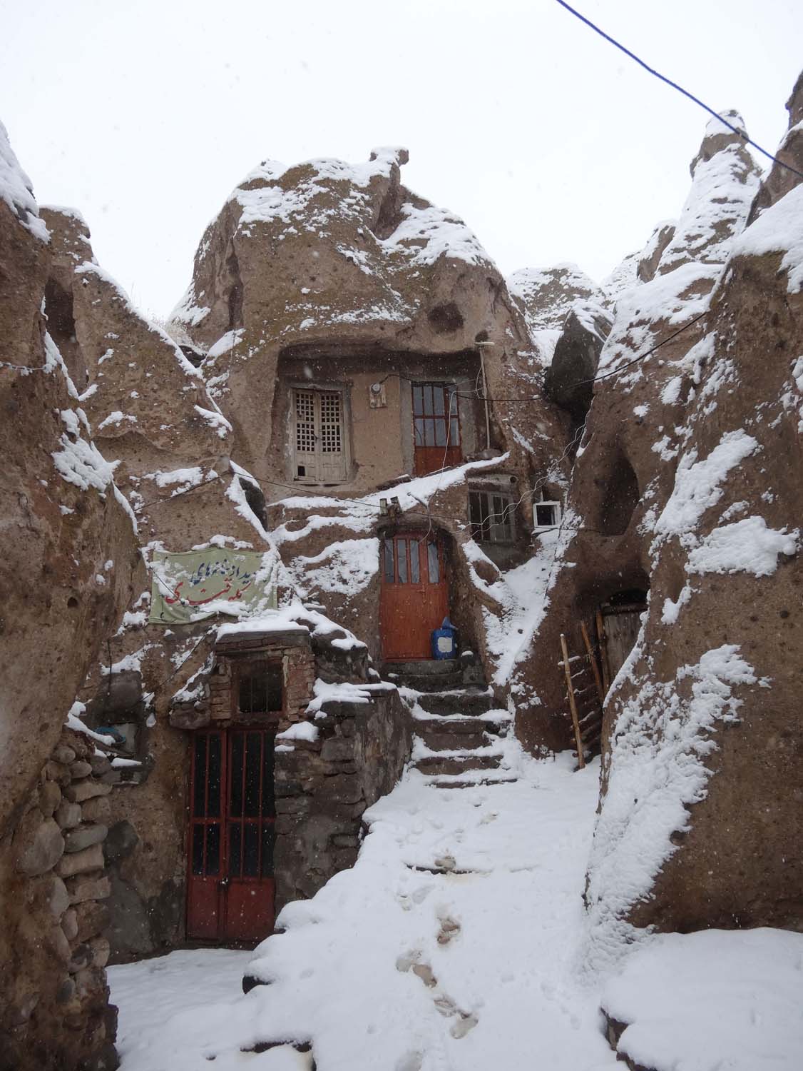 snow in Kandovan where they still live in homes made in caves
