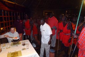 Jude cutting the cake whilst the Masai hum their sung
