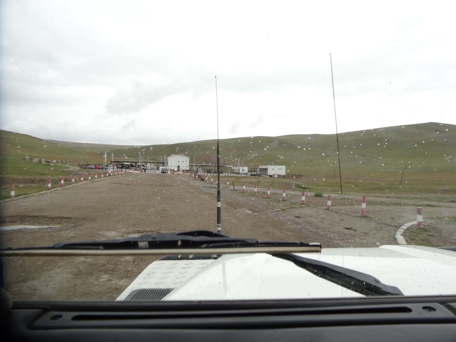 view of the Mongolian border post with the Mongol Rally people parked on the left. Leaving Mongolia you drive to the right hand side of the building and park there before entering the white building in the middle.